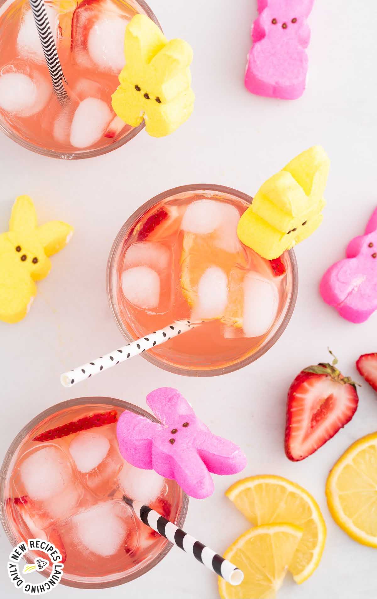 overhead shot of cocktails in glasses with sliced strawberries and lemons garnished with PEEPS Bunny candy with a straw