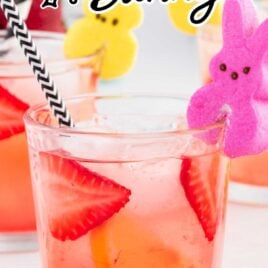 close up shot of a cocktail in a glass with sliced strawberries and lemons garnished with PEEPS Bunny candy with a straw