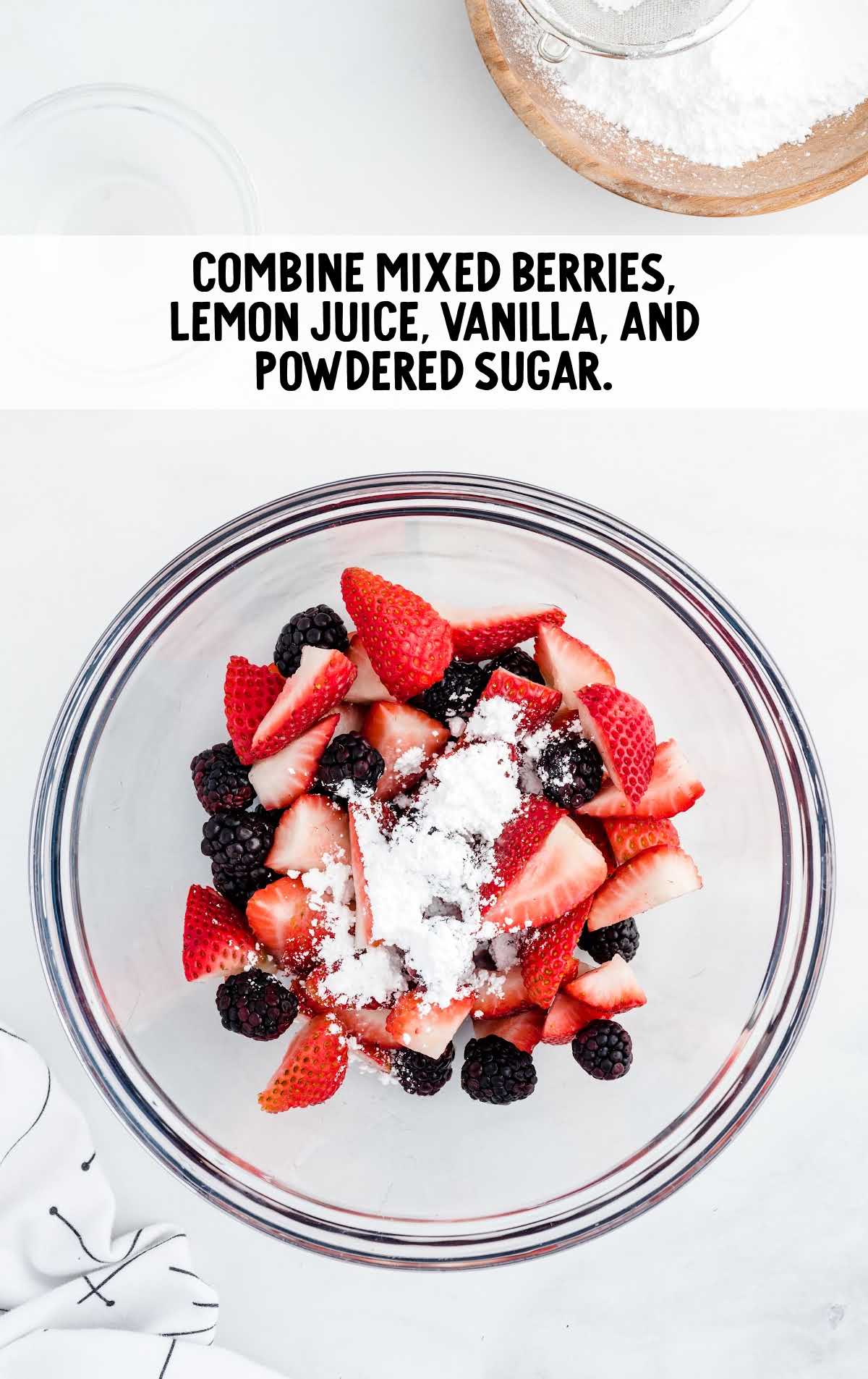 mixed berries, lemon juice, vanilla, and powdered sugar added to a bowl