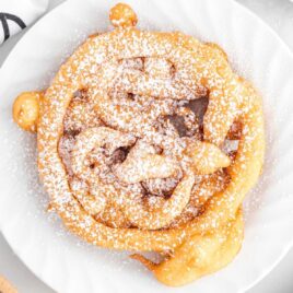 close up overhead shot of a Funnel Cake sprinkled with powdered sugar