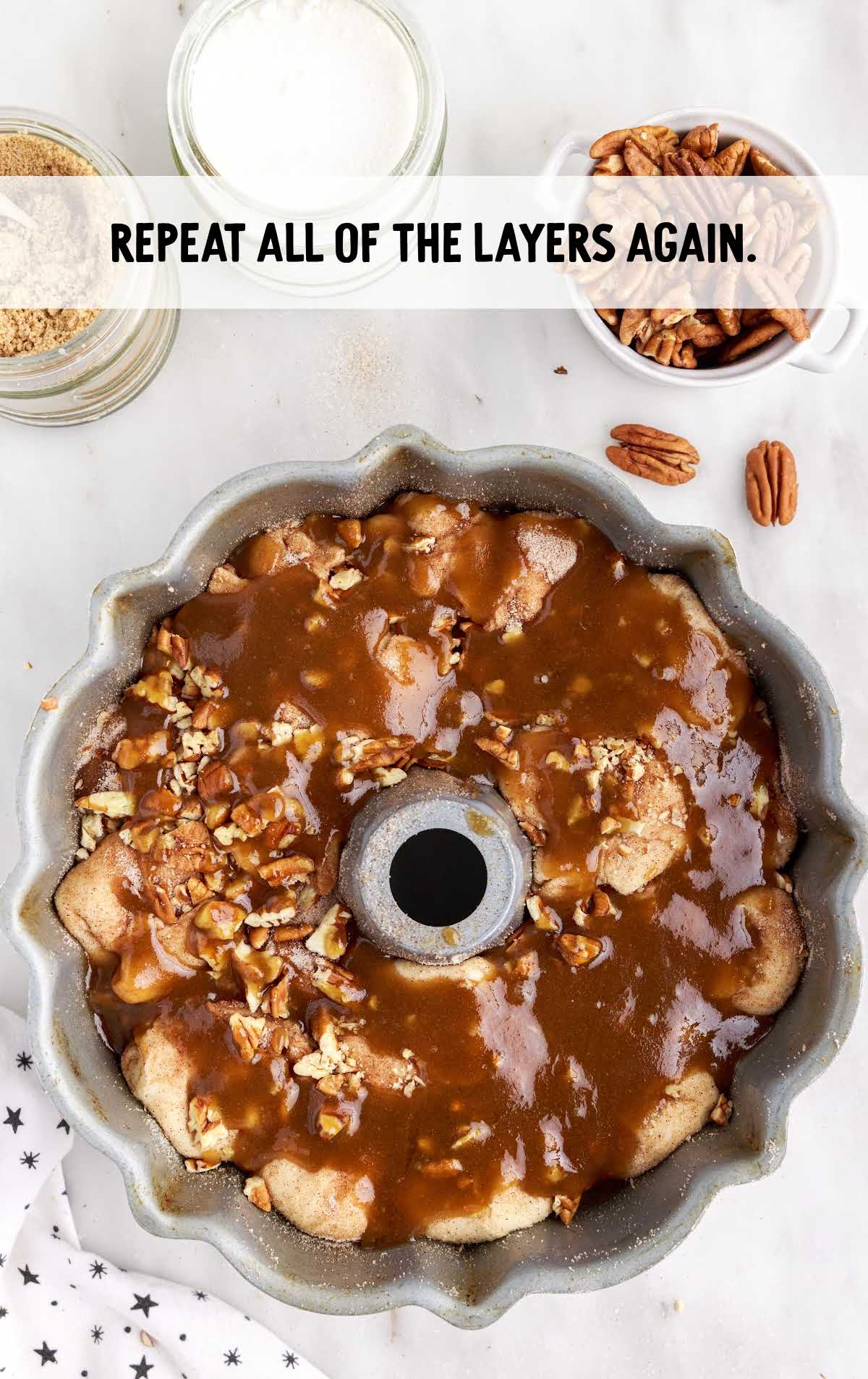bundt pan layered with biscuit, chopped pecans, and glaze