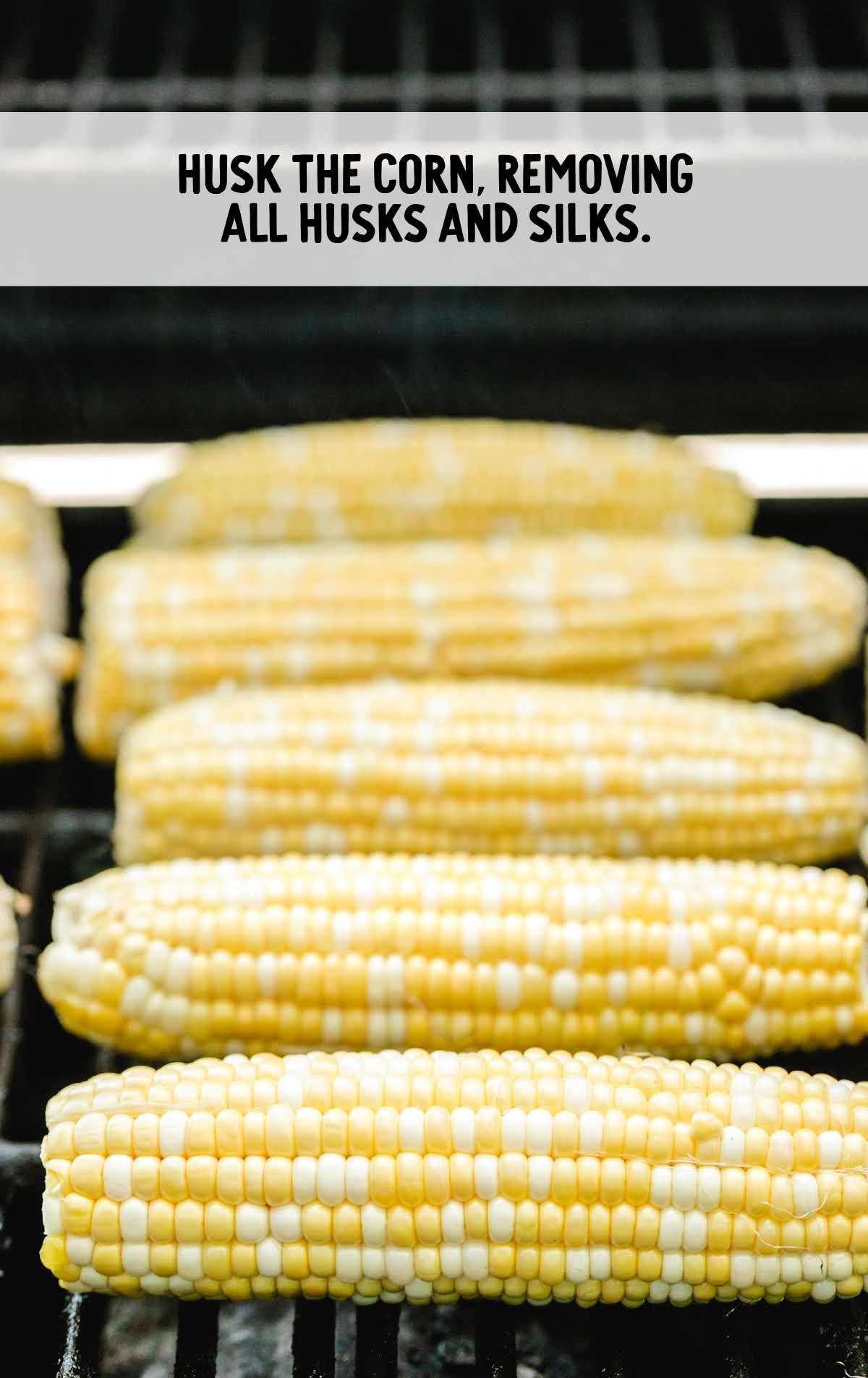 corn husked and placed on a grill