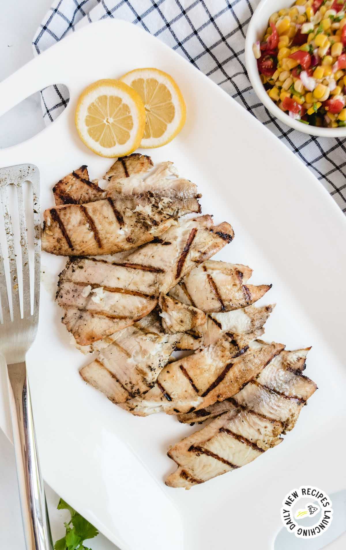 overhead shot of a plate of grilled tilapia with slices of lemon