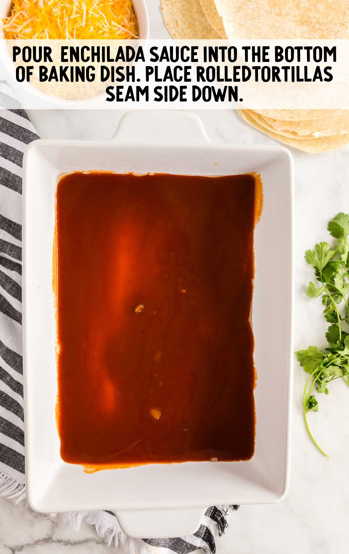 enchilada sauce placed at the bottom of a baking dish