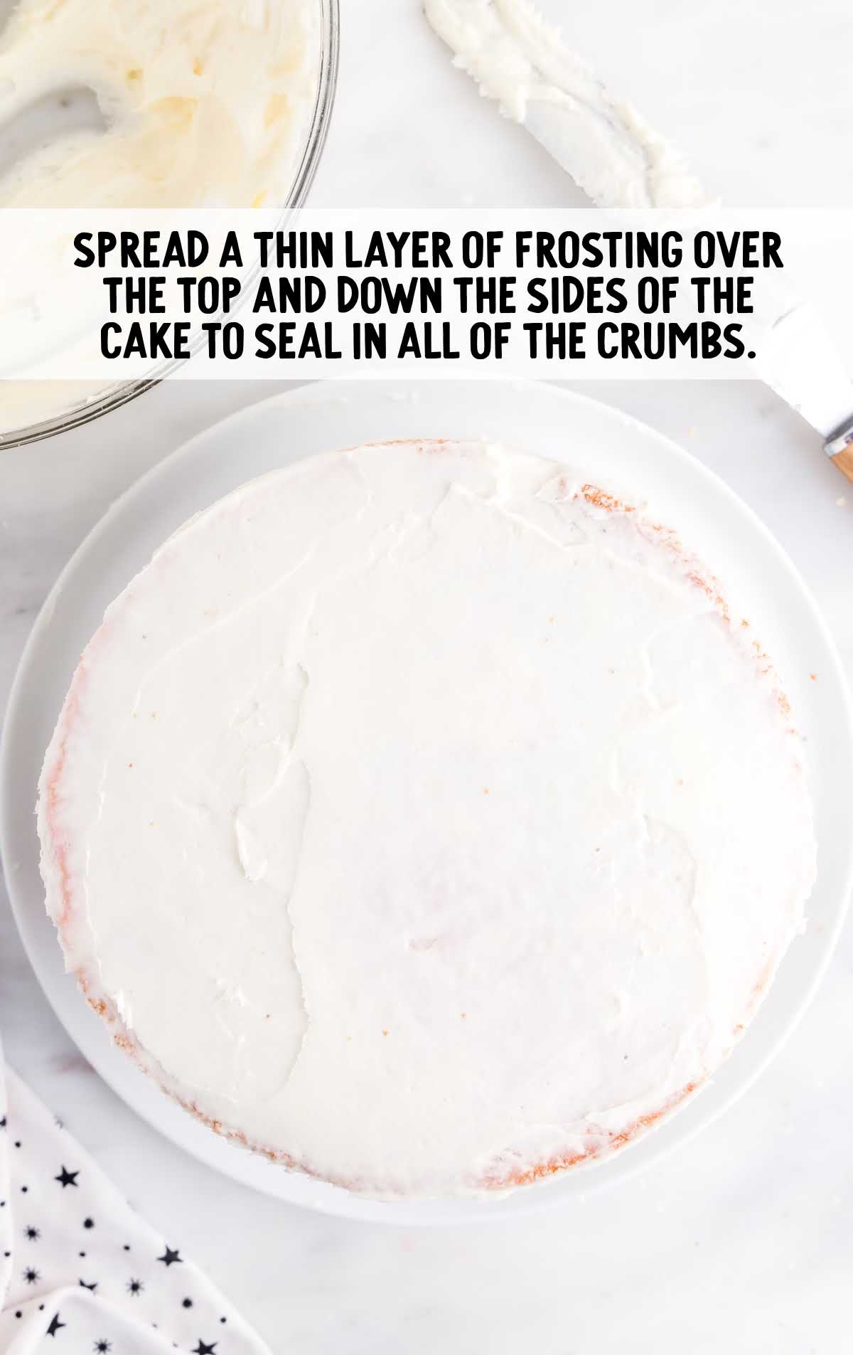thin layer of frosting spread on top of the strawberry cake layer