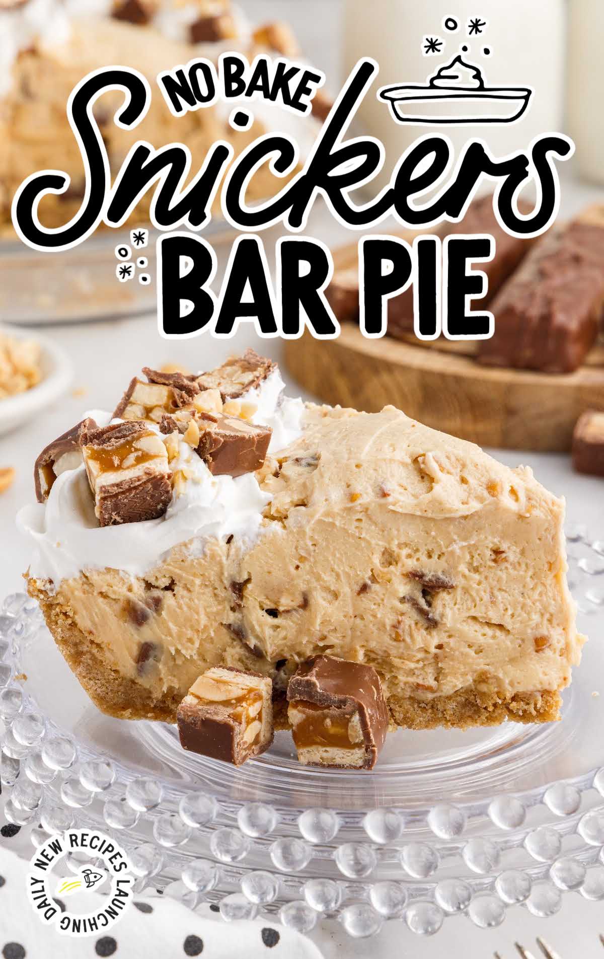 close up shot of a slice of pie topped with pieces of snickers on a plate