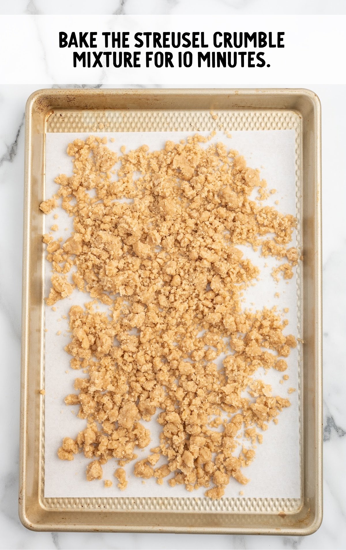 The streusel is spread out on a baking sheet.