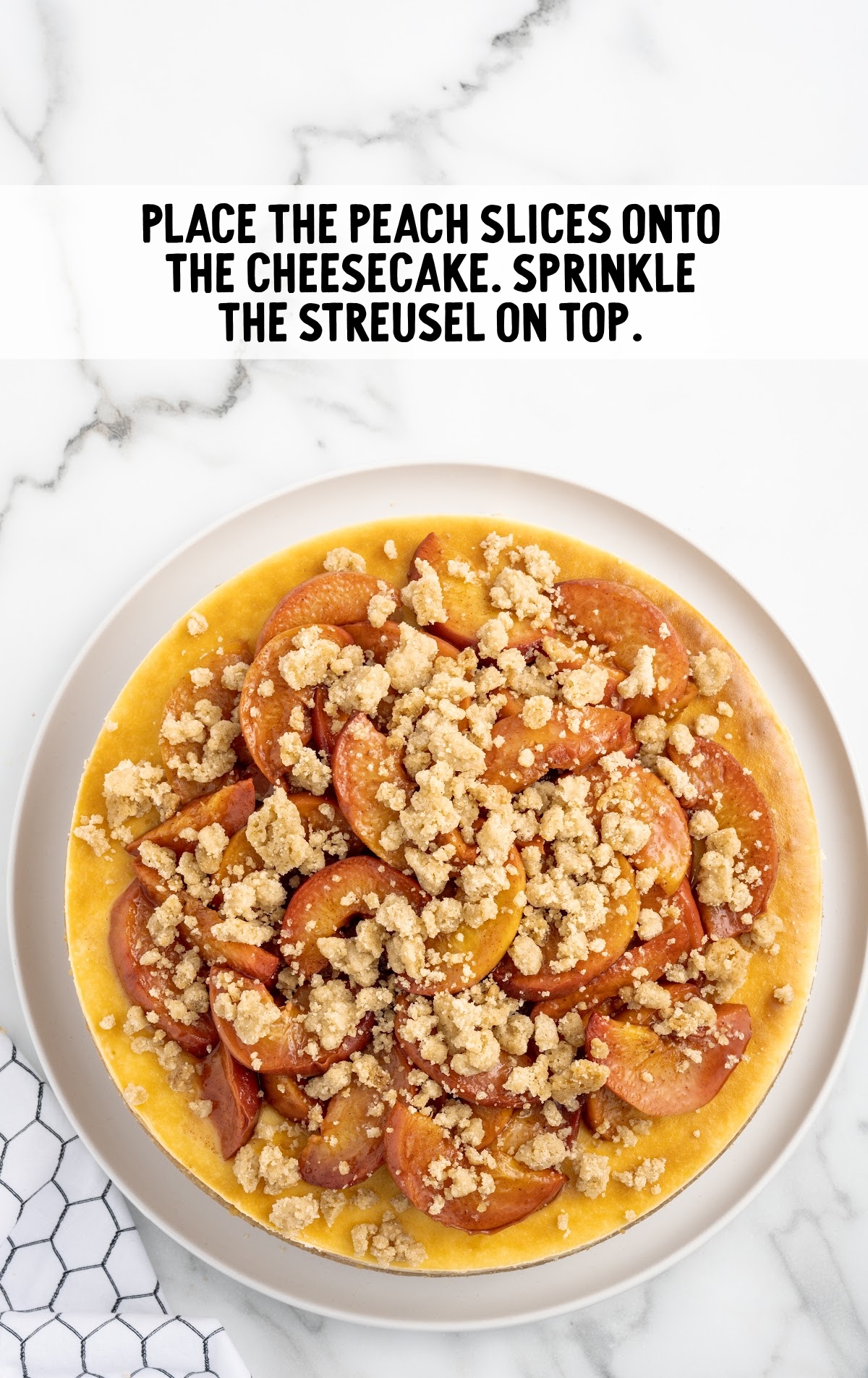 The cheesecake is topped with roasted peaches and streusel.