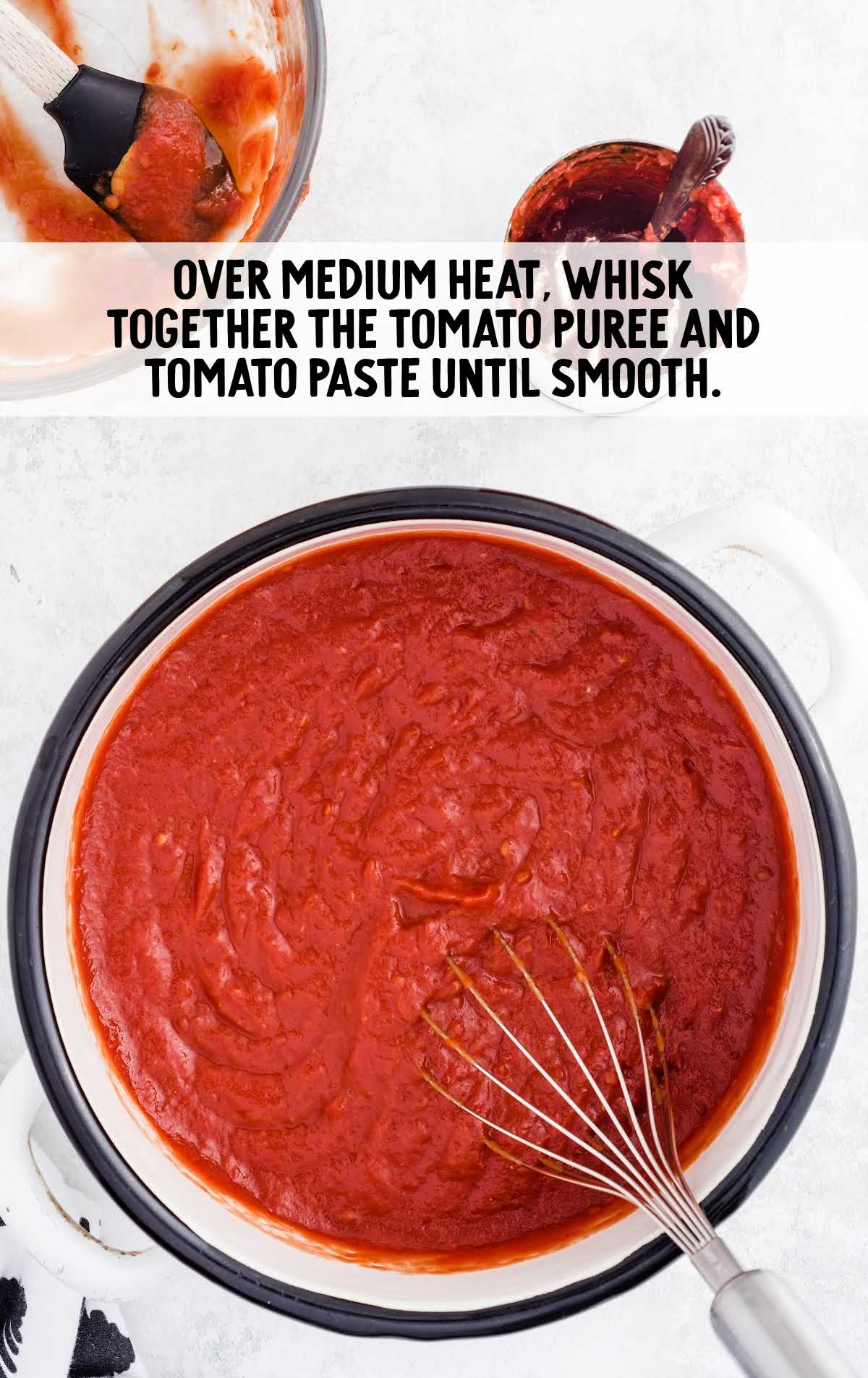 tomato paste and tomato purée whisked together in a saucepan