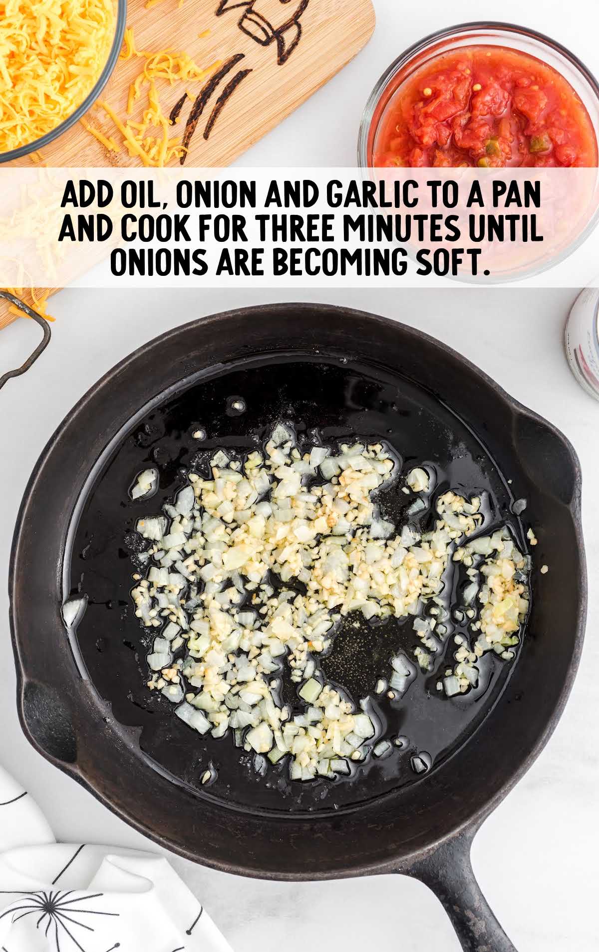 oil, onion, and garlic being cooked in a skillet