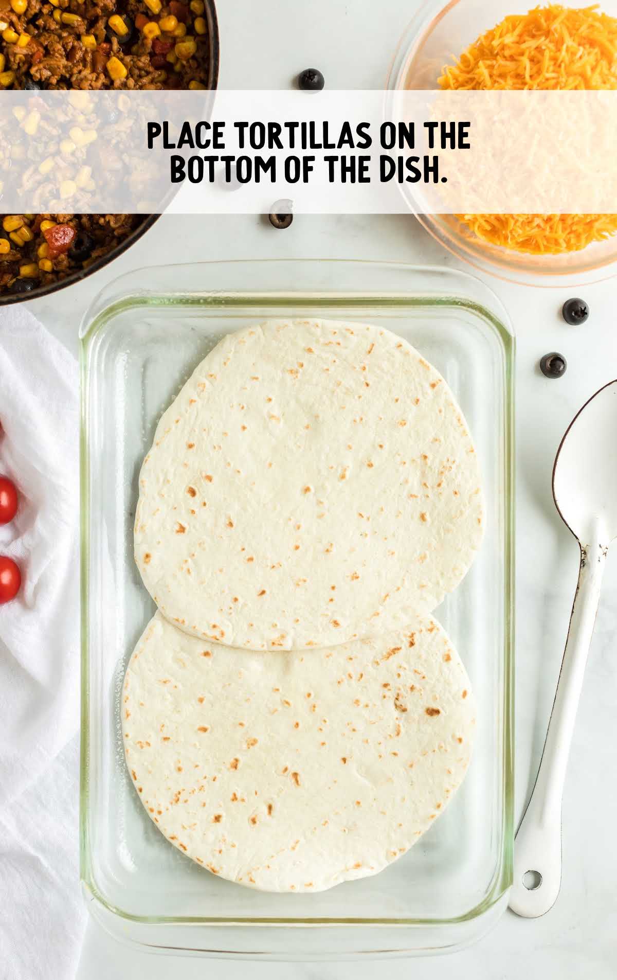 tortillas placed at the bottom of a baking dish