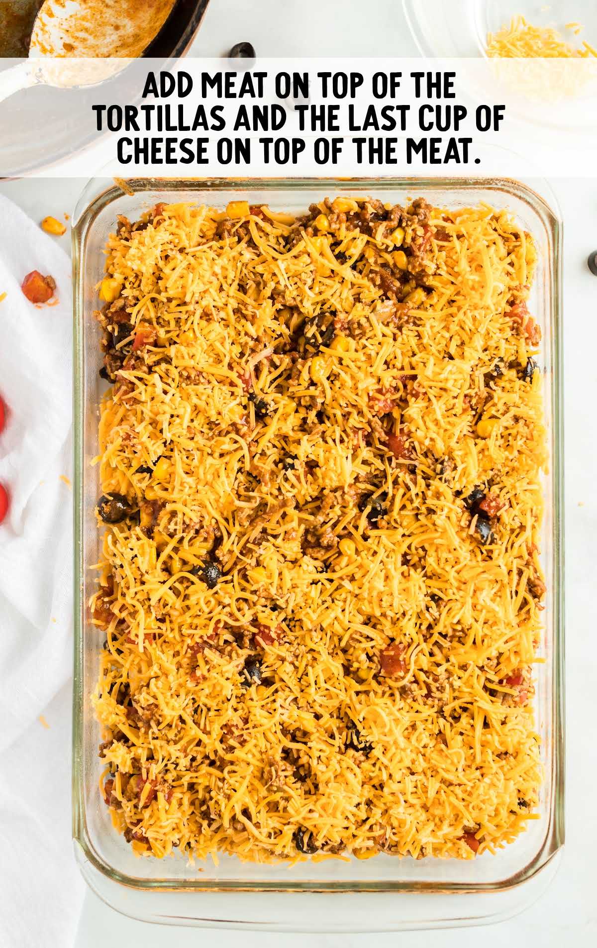 meat mixture, cheese, and tortillas added to a baking dish
