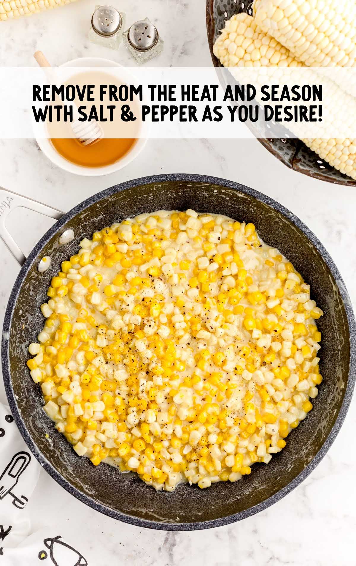 cooked corn seasoned with additional salt and pepper in a skillet