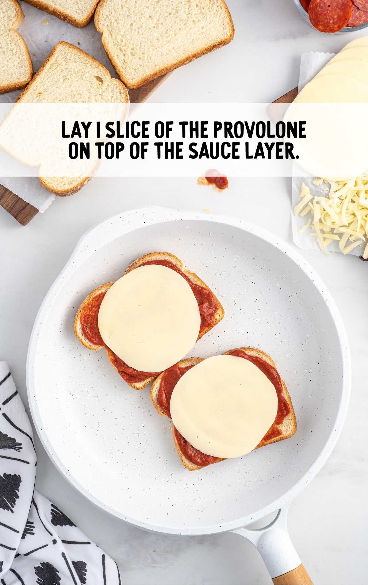 slice of provolone placed on top of the pizza sauce