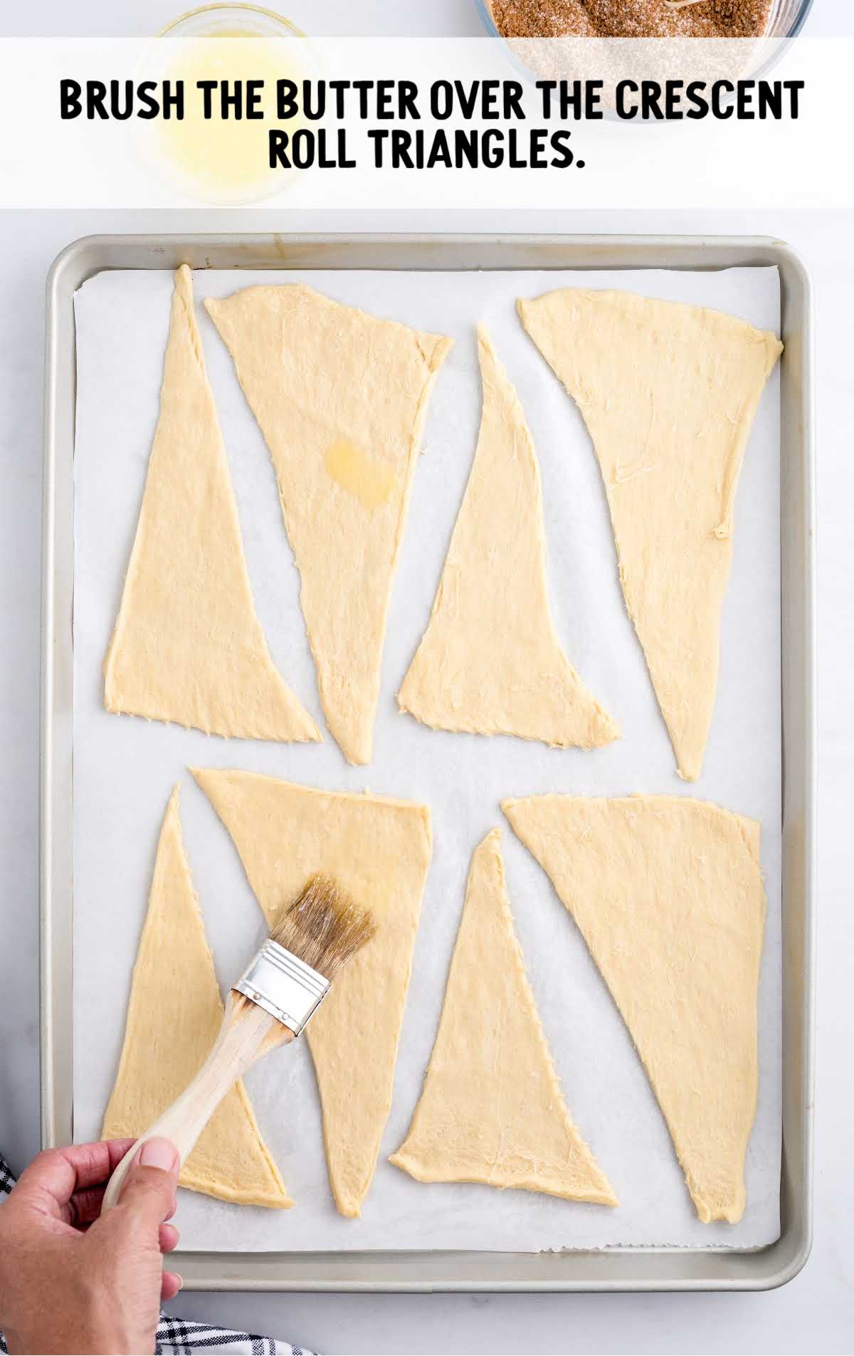 butter brushed into the crescent roll triangles on a baking dish