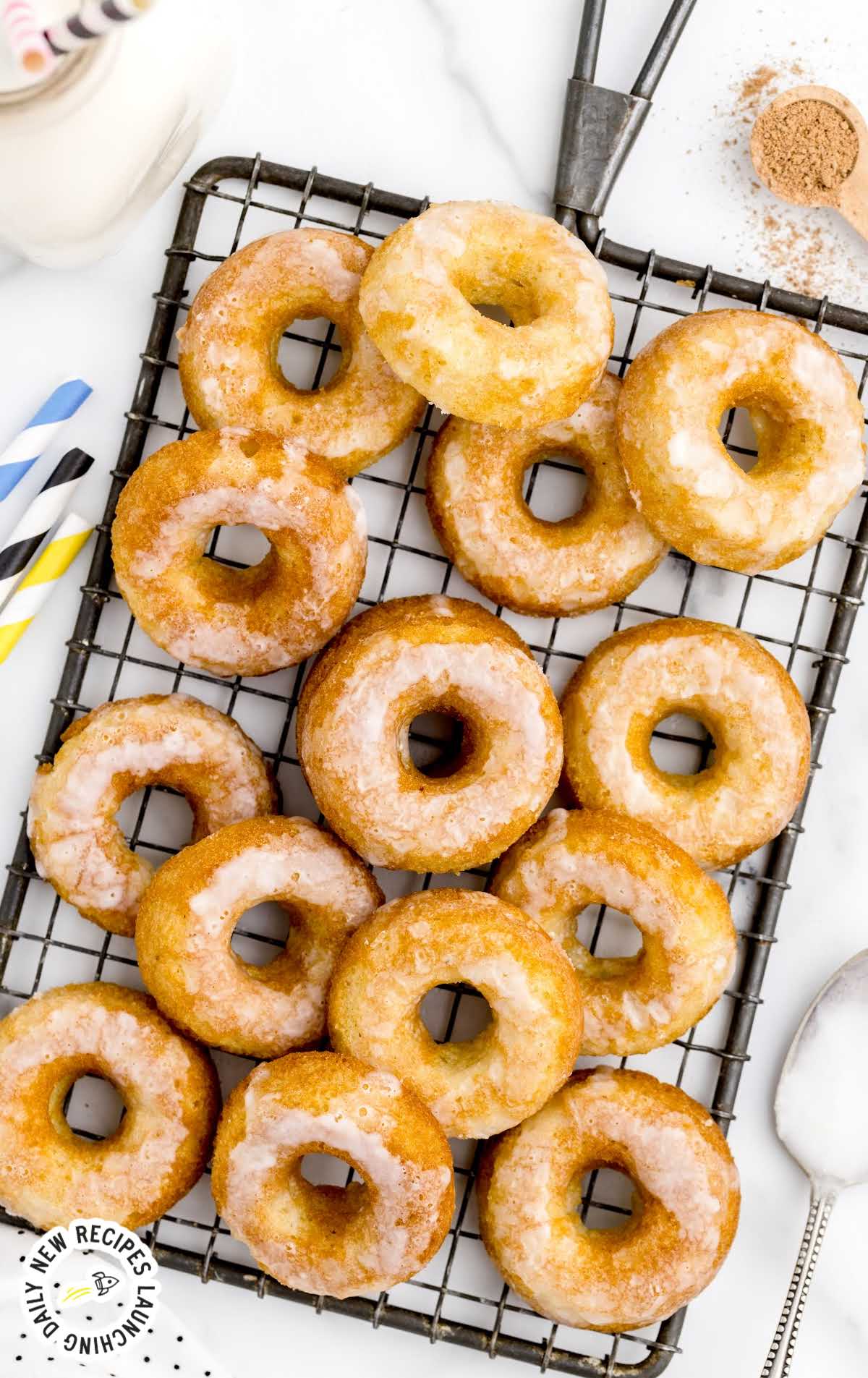close up overhead shot of Sour Cream Donuts topped with glaze on a cooling rack