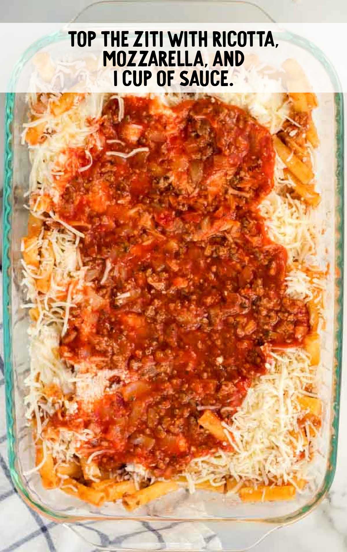 ziti topped with cheeses and sauce in a baking dish