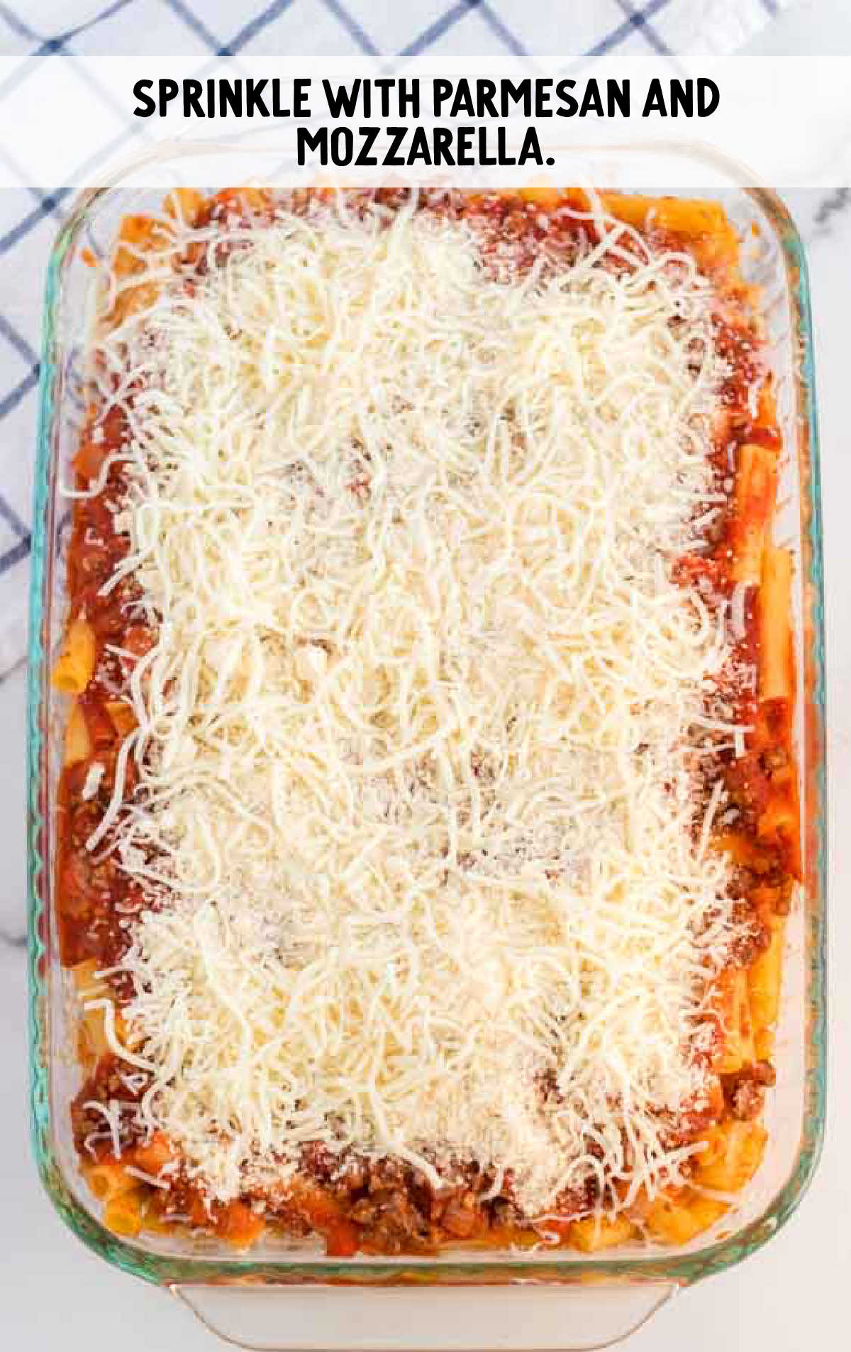 ziti topped with cheeses in the baking dish