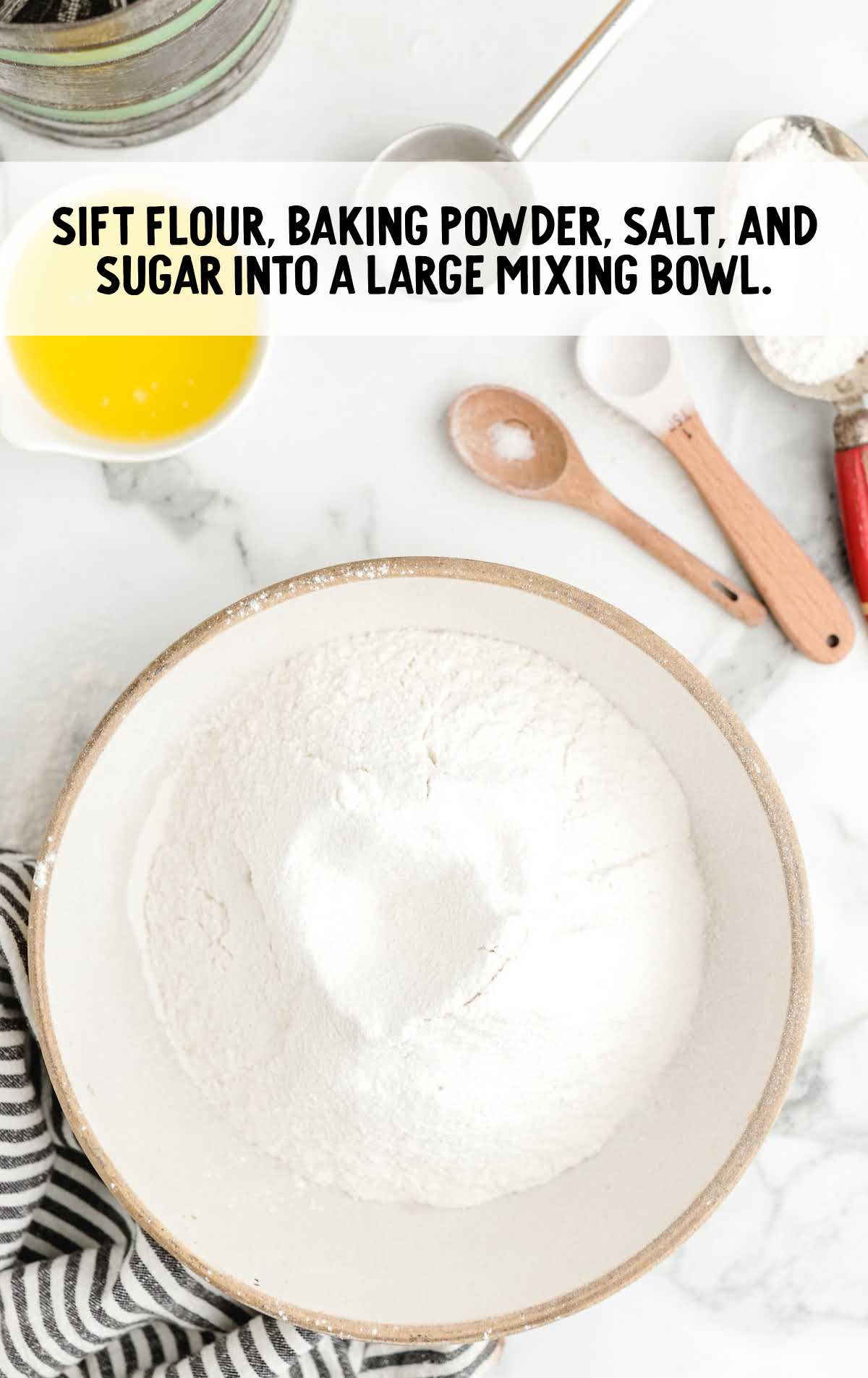 flour, baking powder, salt, and sugar added to a bowl