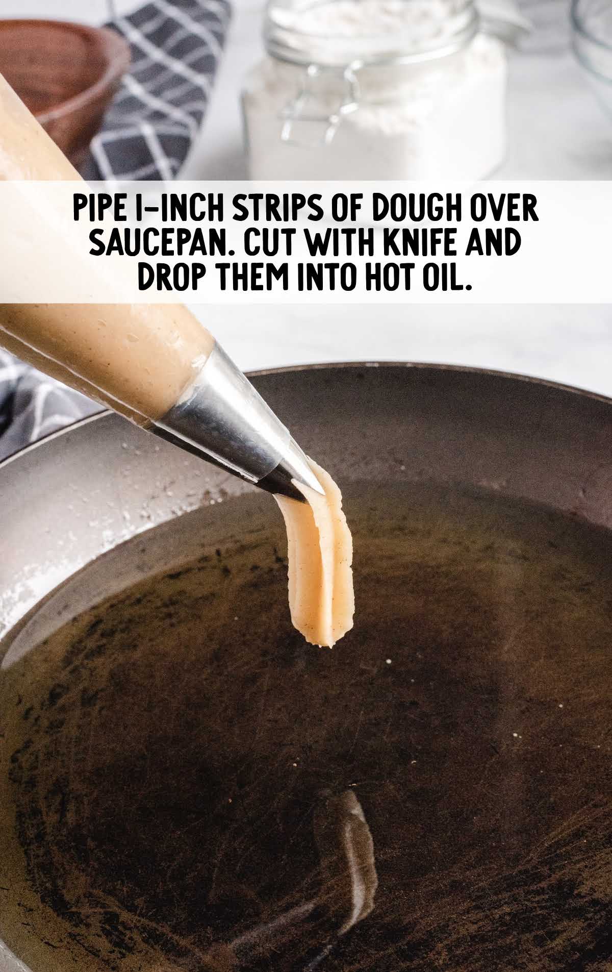 strips of dough dripped into a pan of hot oil