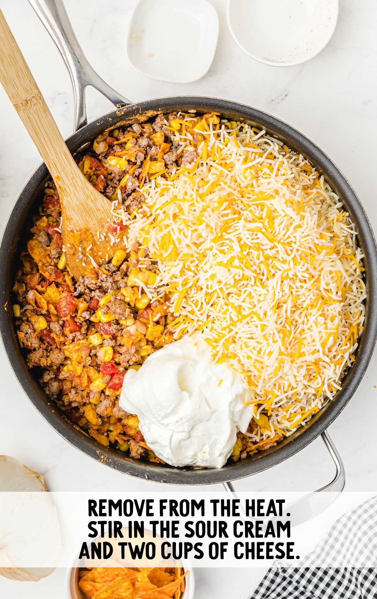 cheese and sour cream added to the ingredients in the skillet