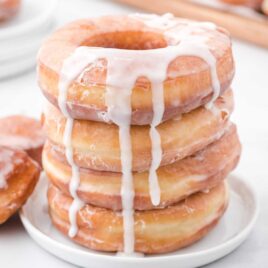 a close up shot of Homemade Glazed Donuts stacked on top of each other