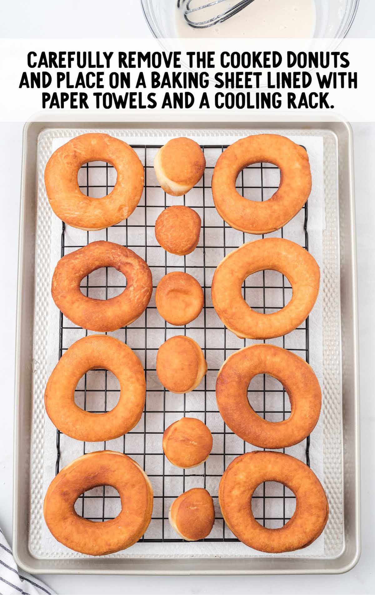 cooked donuts on a cooling rack and baking sheet