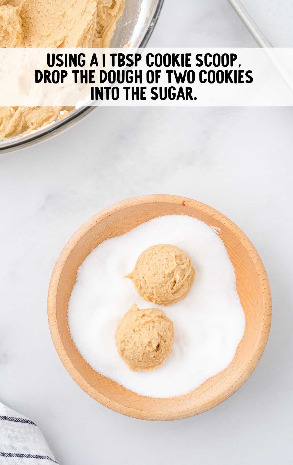 dough rolled into the sugar in a bowl