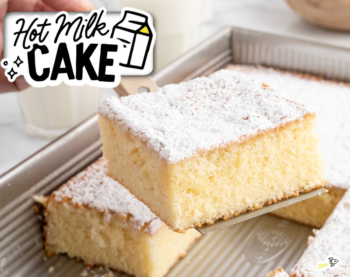 Hot milk cake slice being lifted from the pan, showing a light, fluffy texture and powdered sugar topping, with a glass of milk in the background.