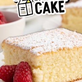 Old-fashioned milk cake slice topped with powdered sugar and raspberries for a vintage recipe pin.