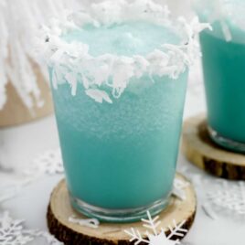 close up shot of Jack Frost Cocktail topped with shredded coconut in a glass