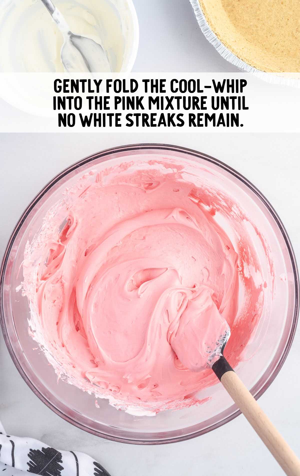 cool whip mixed into the pink mixture in a bowl