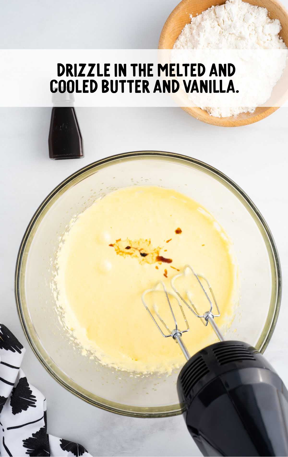 butter and vanilla blended together with Lemon Custard Cake batter in a bowl