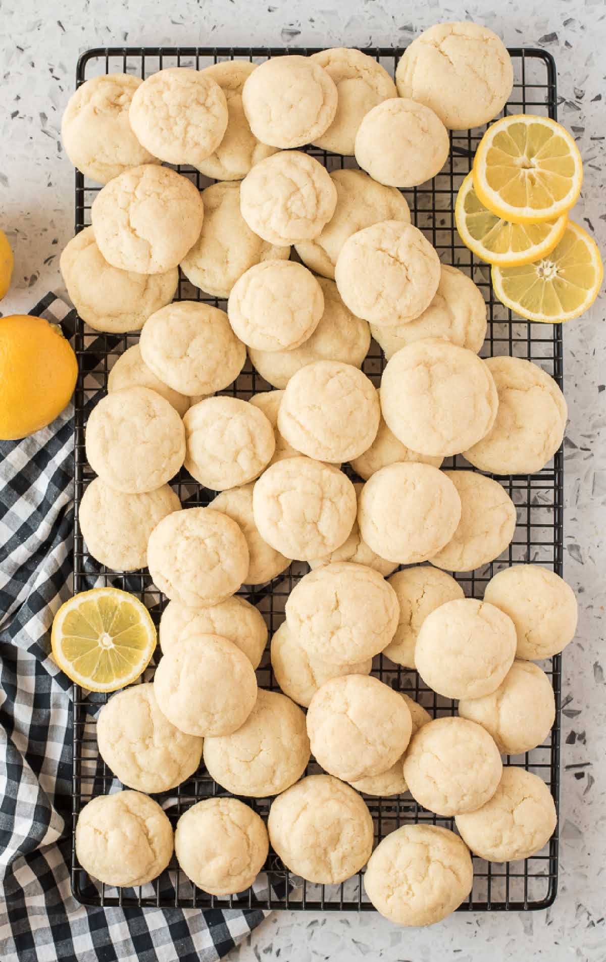 overhead shot of Lemon Sugar Cookies on a cooling rack with slices of lemon