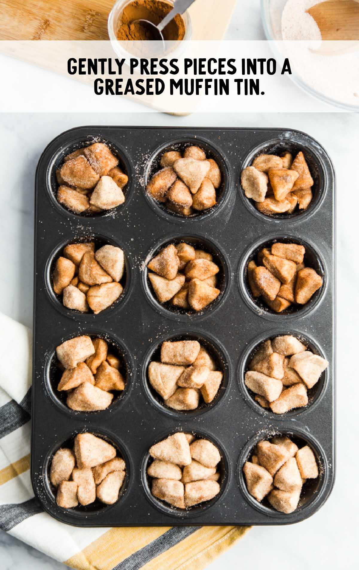 biscuit pieces placed in a muffin pan