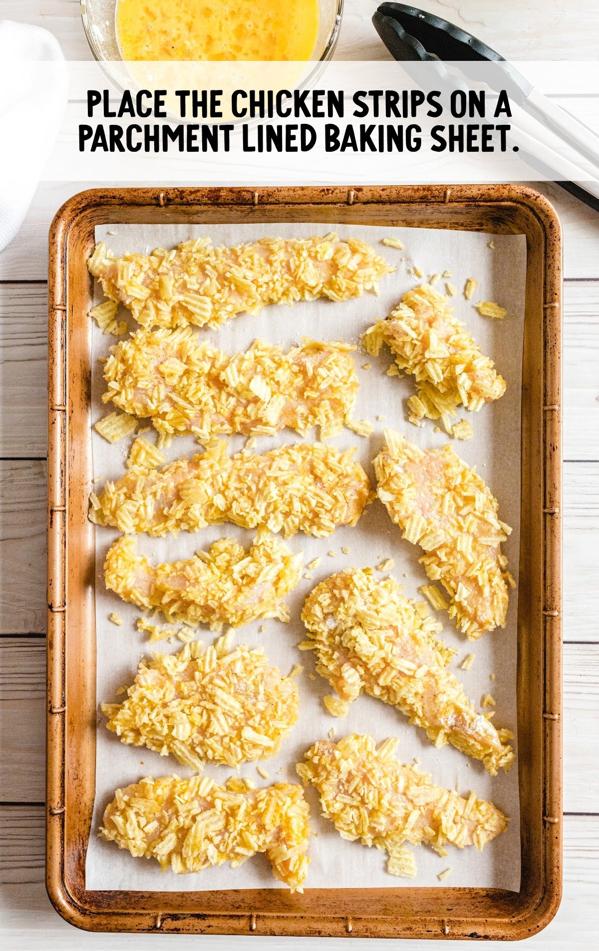 chicken strips placed on a parchment lined baking sheet
