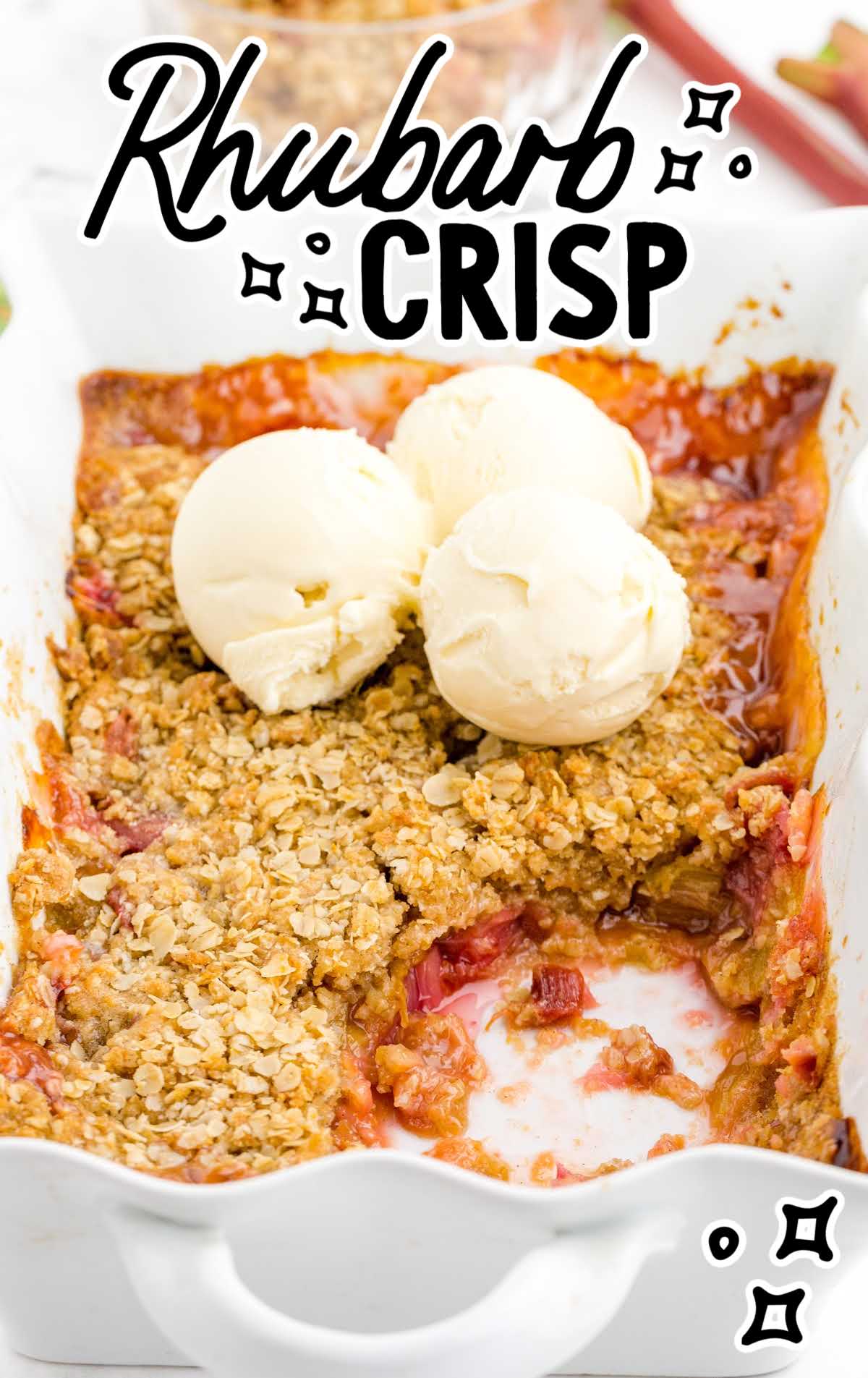 close up shot of Rhubarb Crisp topped with scoops of vanilla ice cream in a baking dish