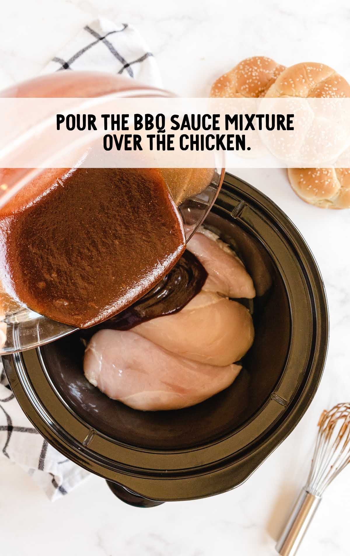 bbq sauce mixture poured over the chicken breast in a slow cooker