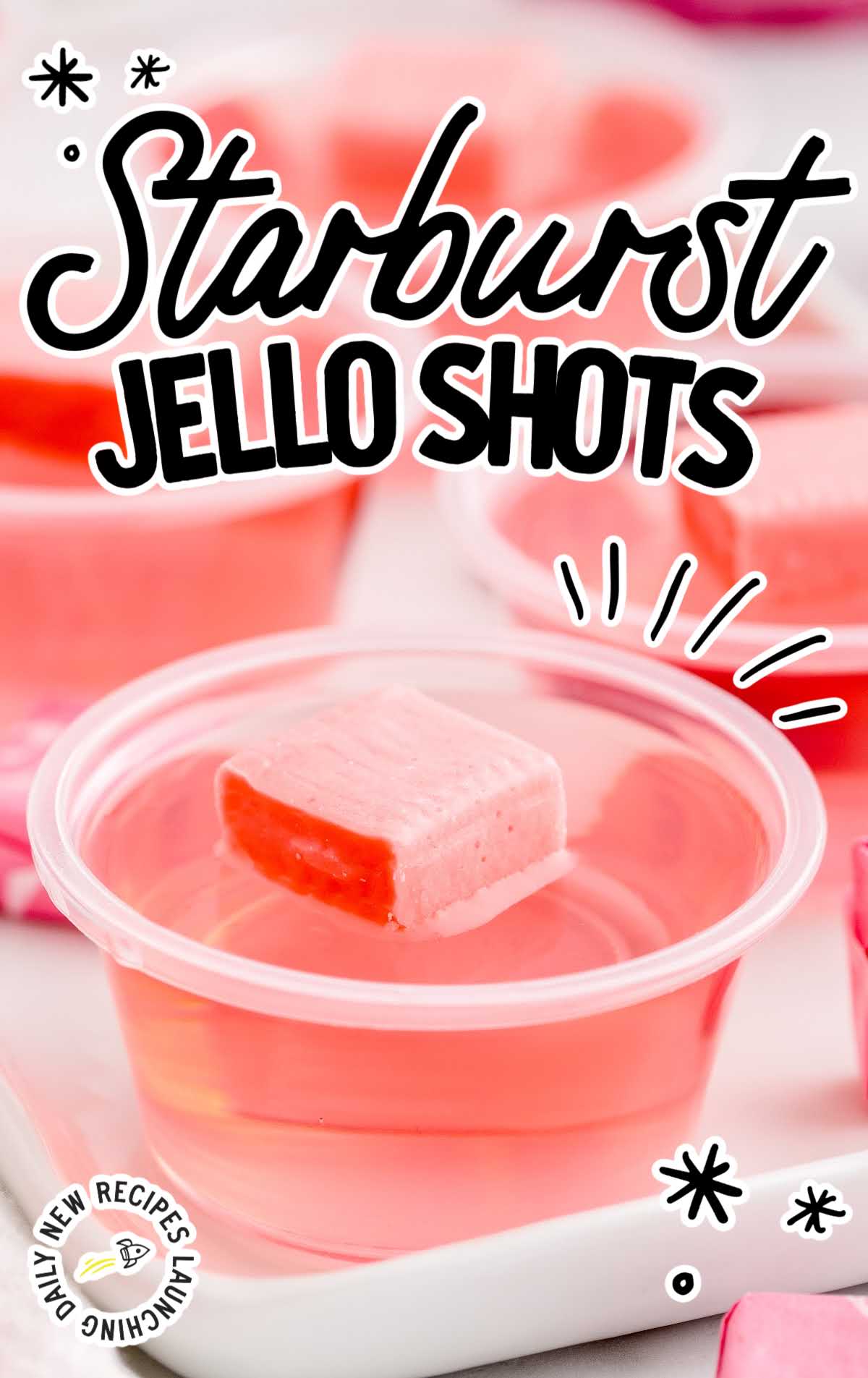 a Starburst Jello Shot in a cup topped with a pink starburst