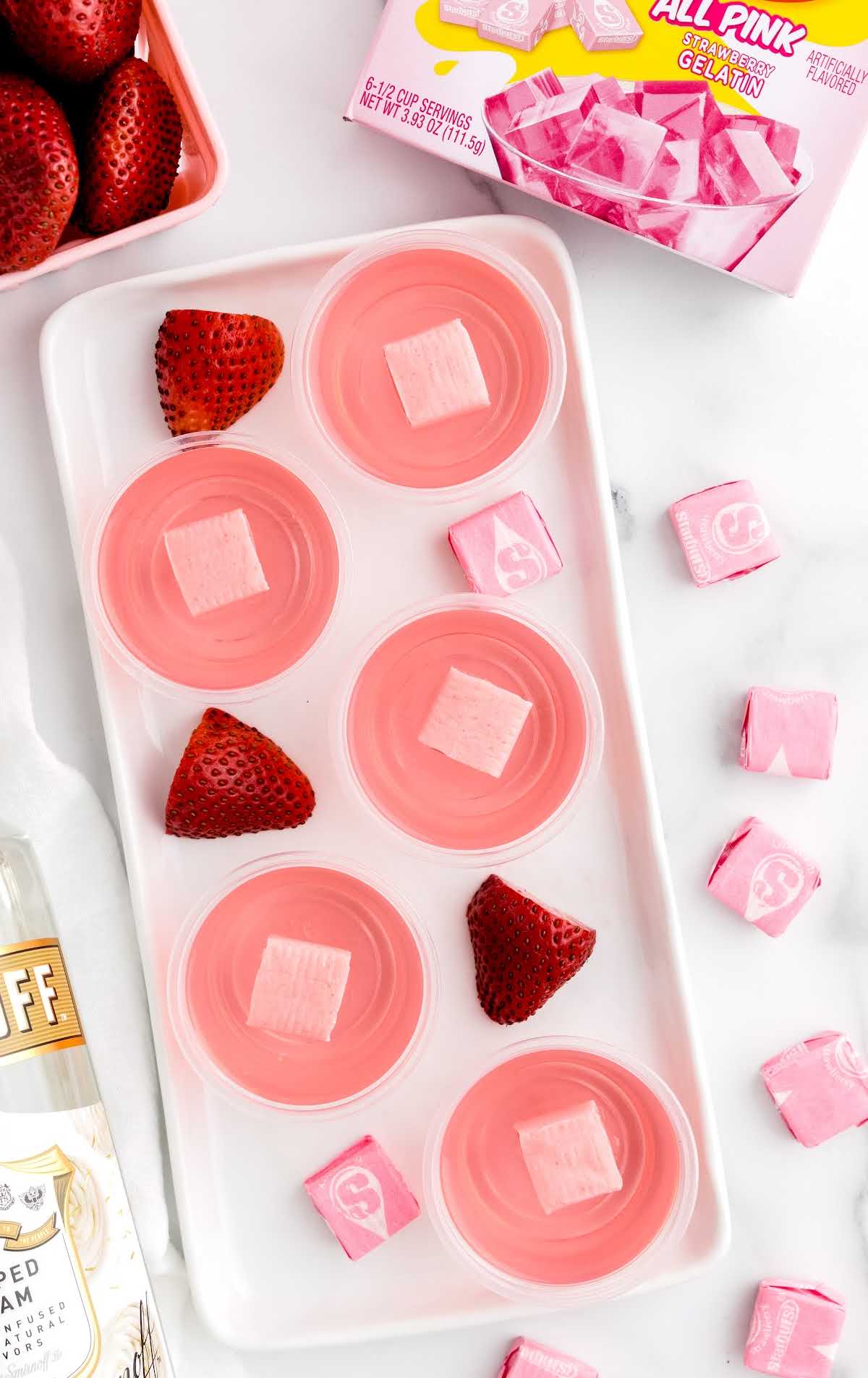 Starburst Jello Shots in a tray with strawberries on the tray
