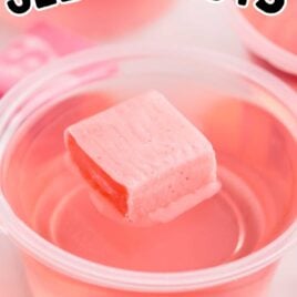 a Starburst Jello Shot in a cup topped with a pink starburst