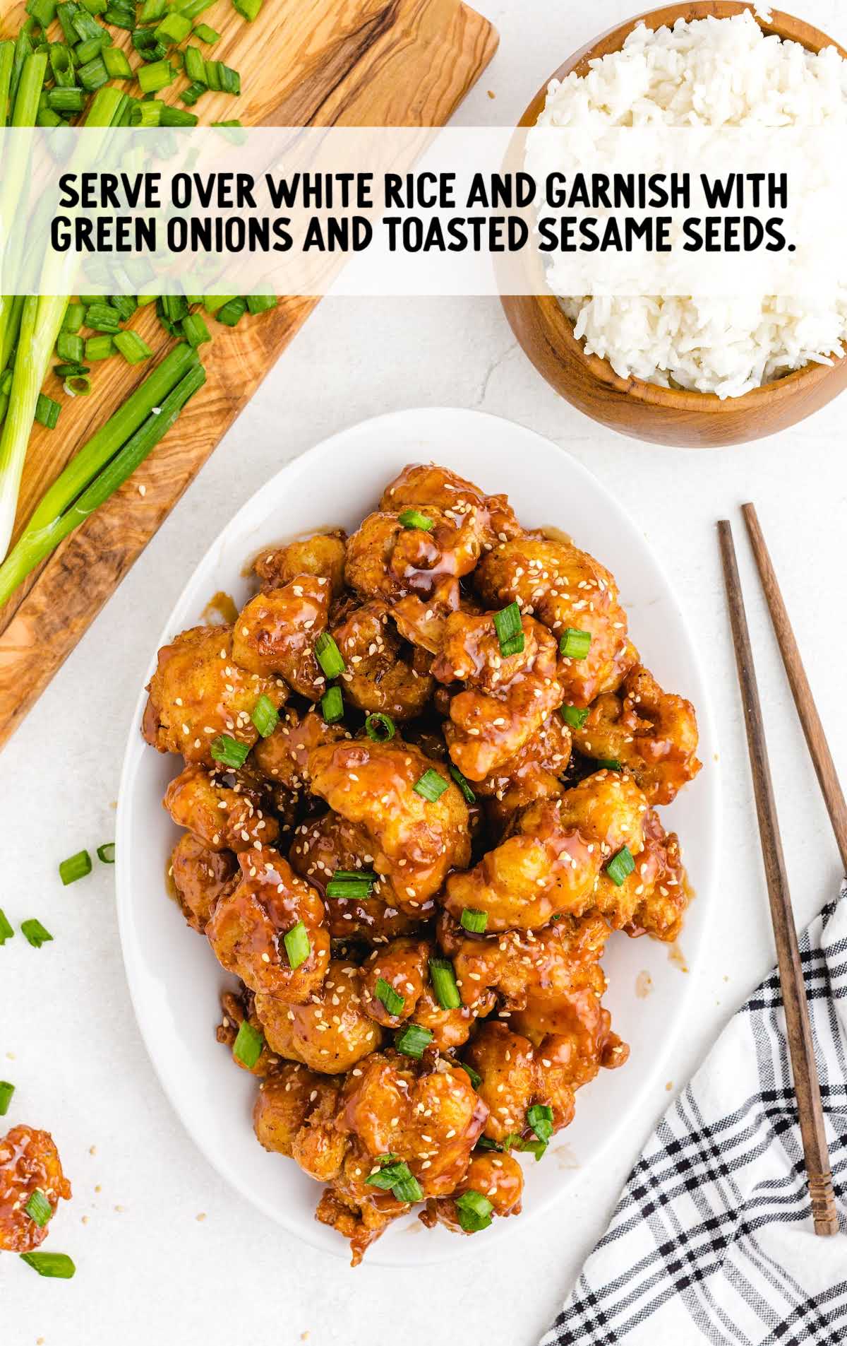 Sticky Sesame Cauliflower garnished with green onions and sesame seeds on a plate