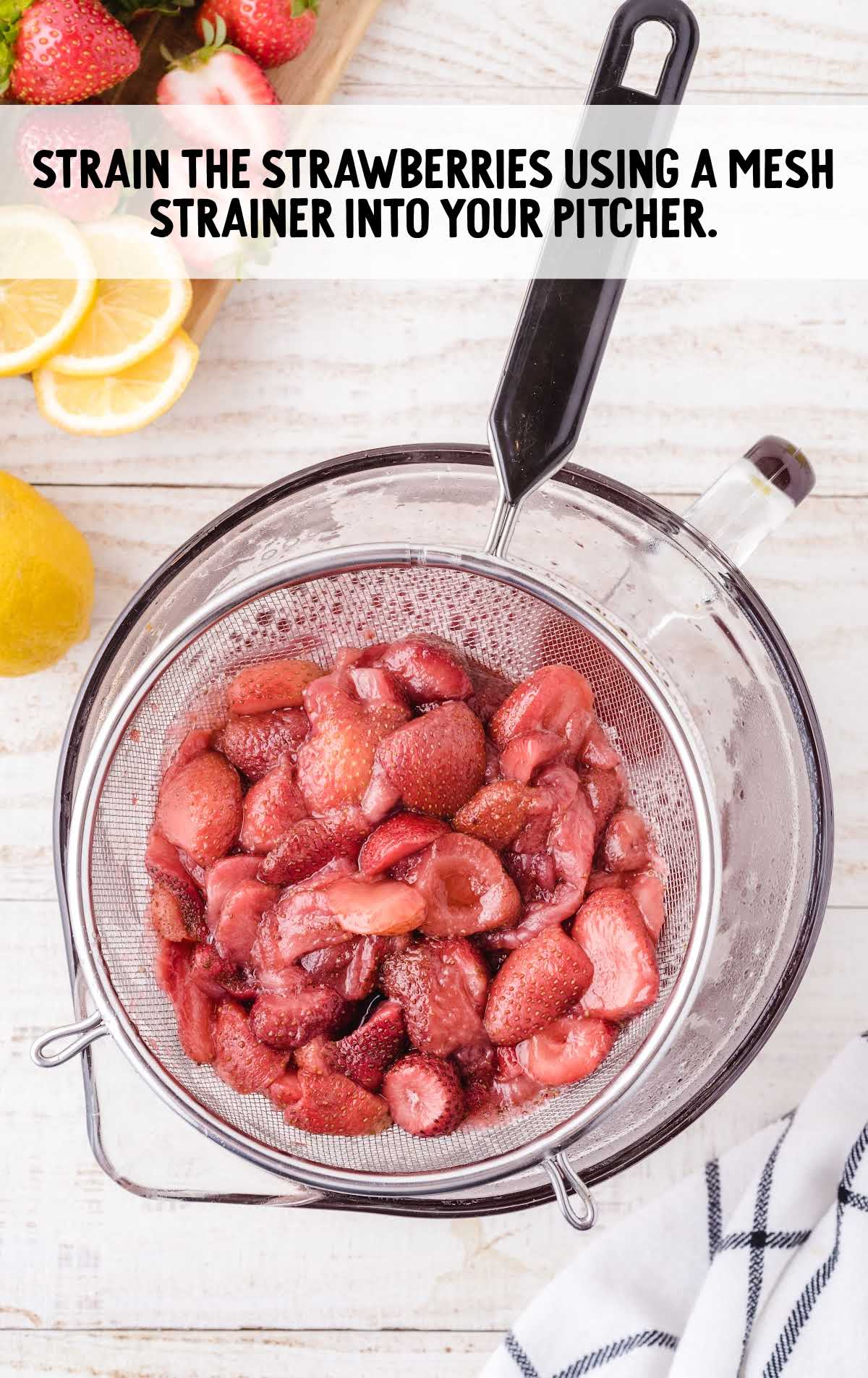 strawberries being strained from the pan using a strainer