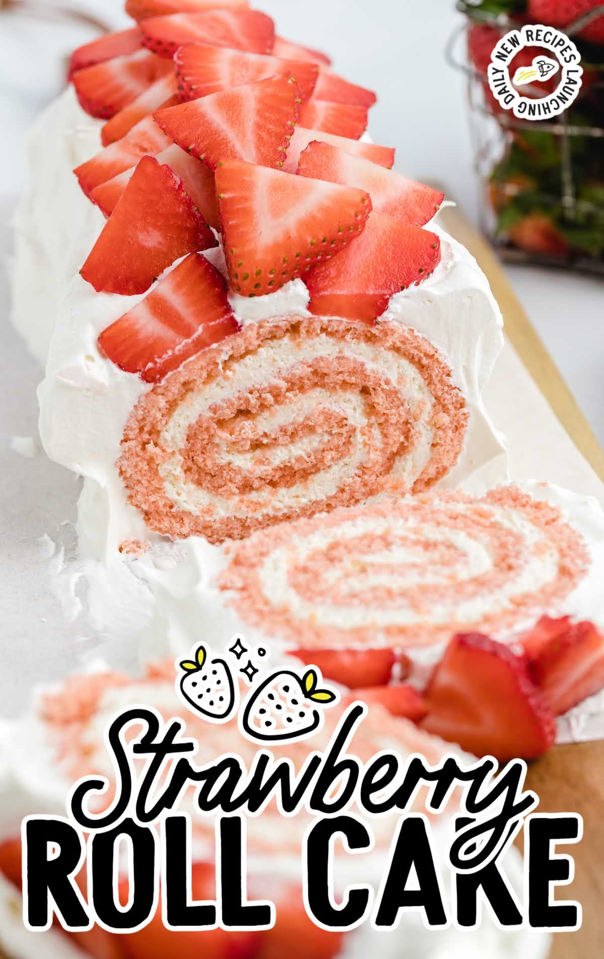 strawberry roll cake garnished with diced strawberries and cut into slices on a wooden board