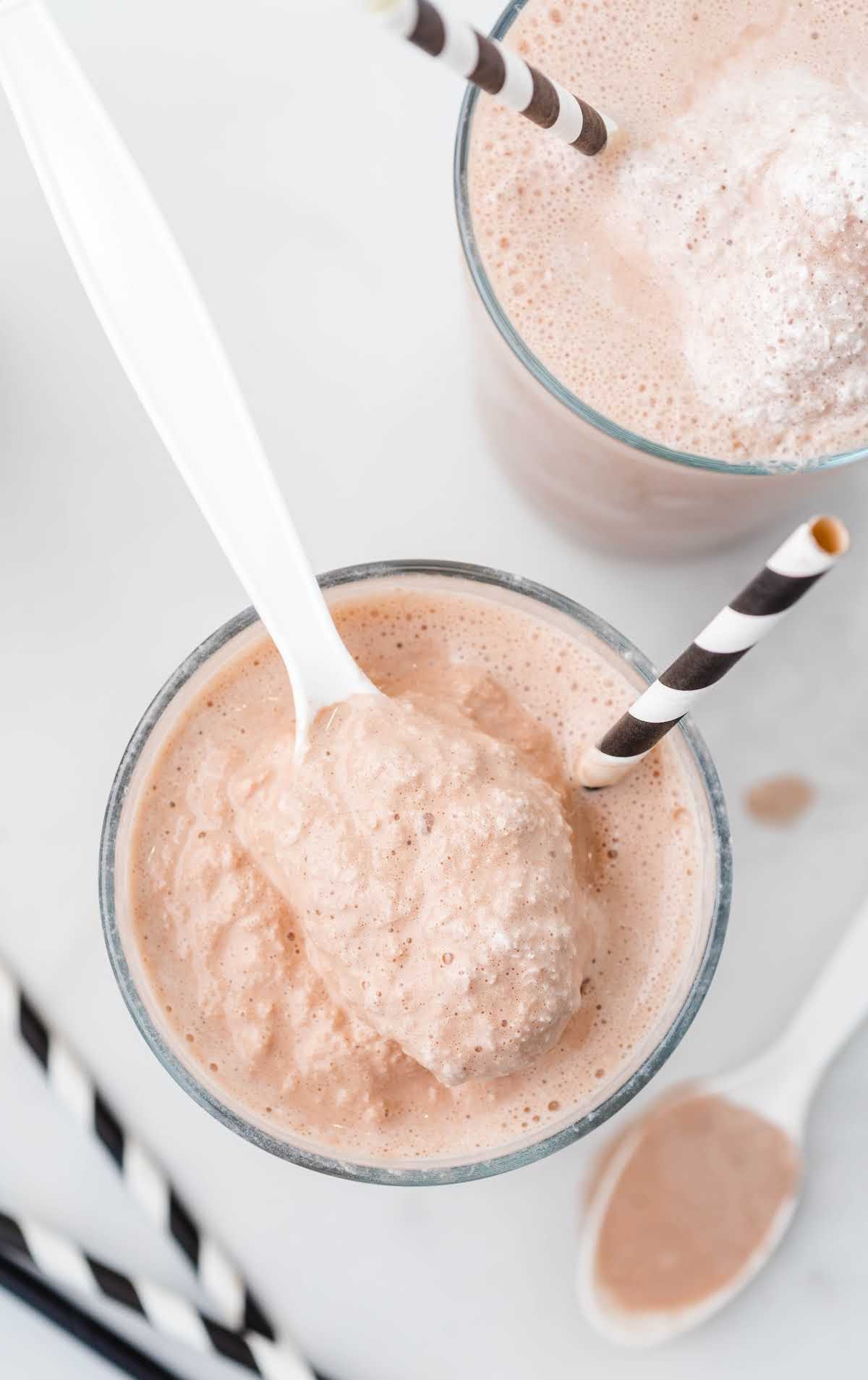 close up overhead shot of homemade Wendy's frosty in a glass cup with a spoon and straw on top