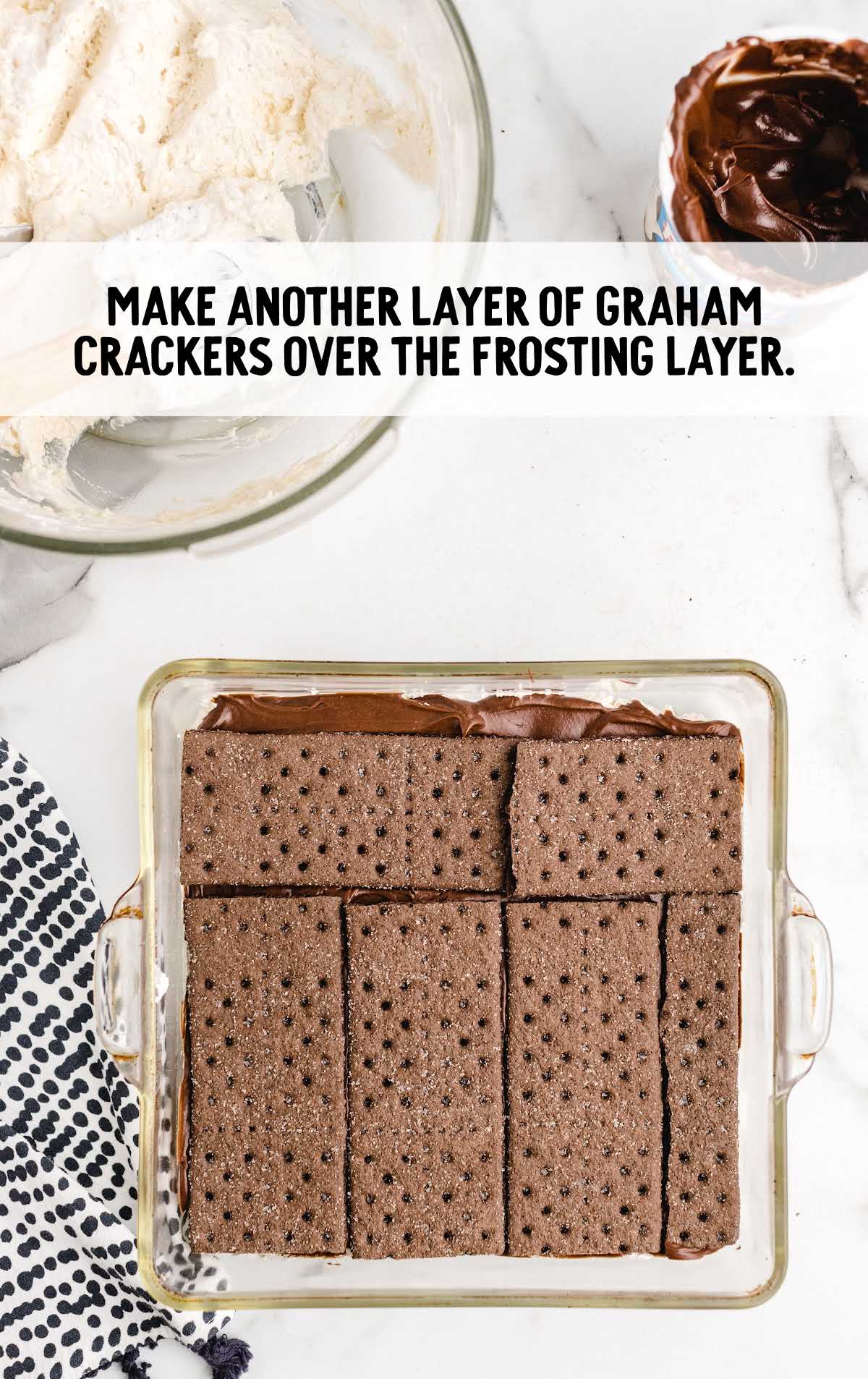 graham crackers layered on top of the frosting layer in the baking dish