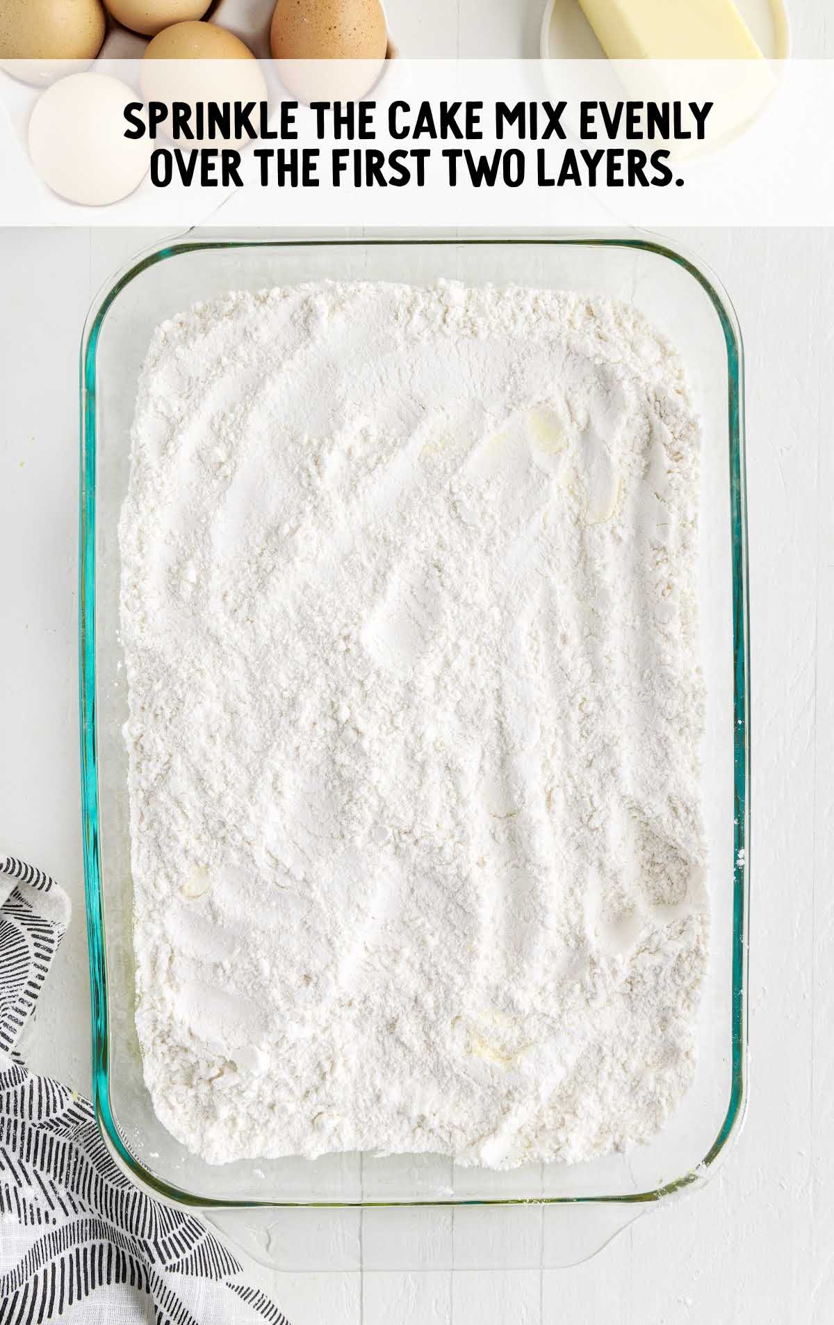 cake mix sprinkled on top of the cream cheese mixture in the baking dish