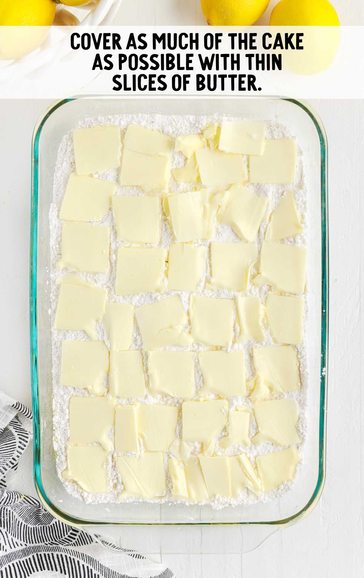 slices of butter placed on top of the cake mixture in a baking dish