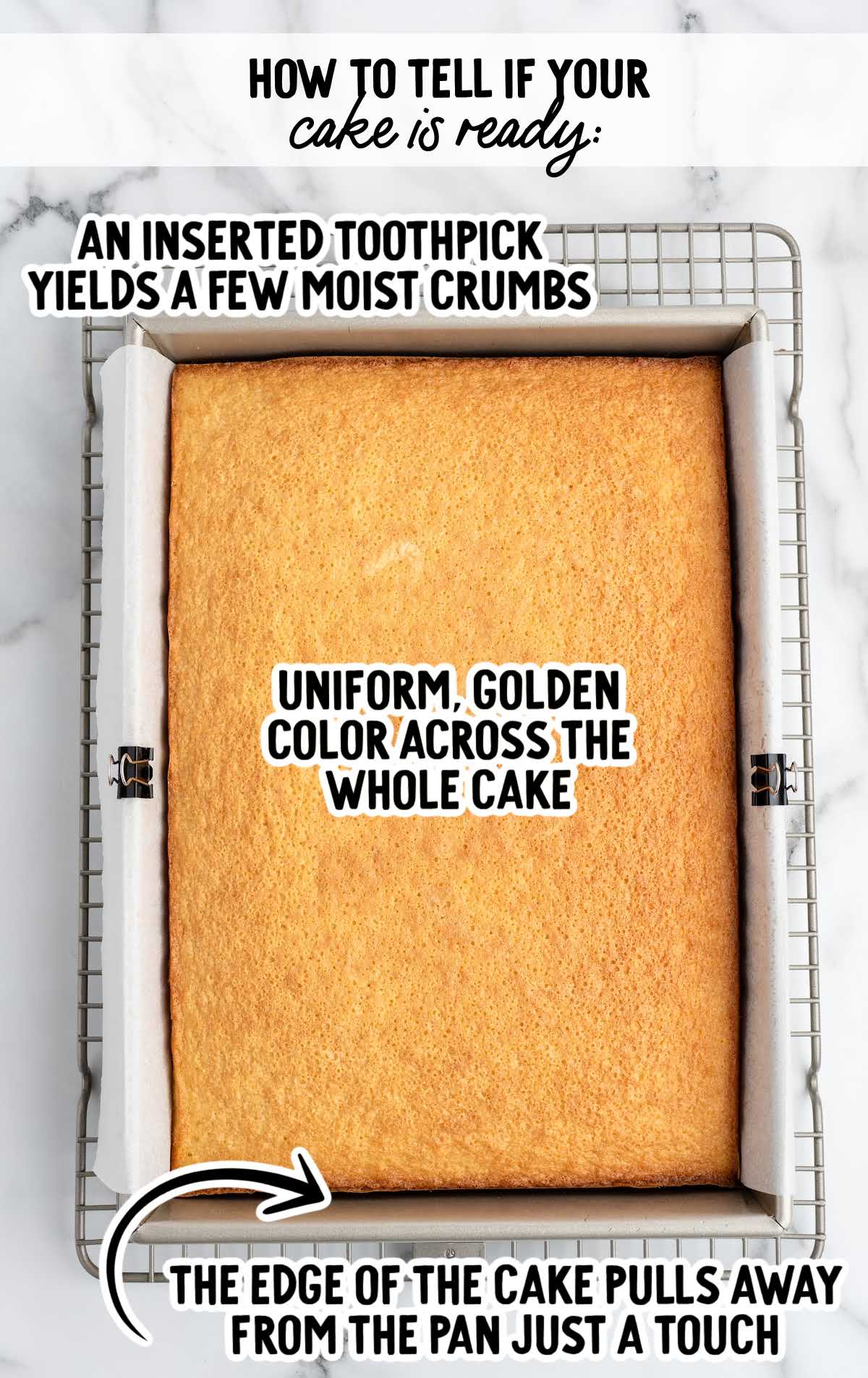 Baked hot milk cake in a pan showing golden color, slightly pulled edges, and notes explaining how to tell when the cake is done.