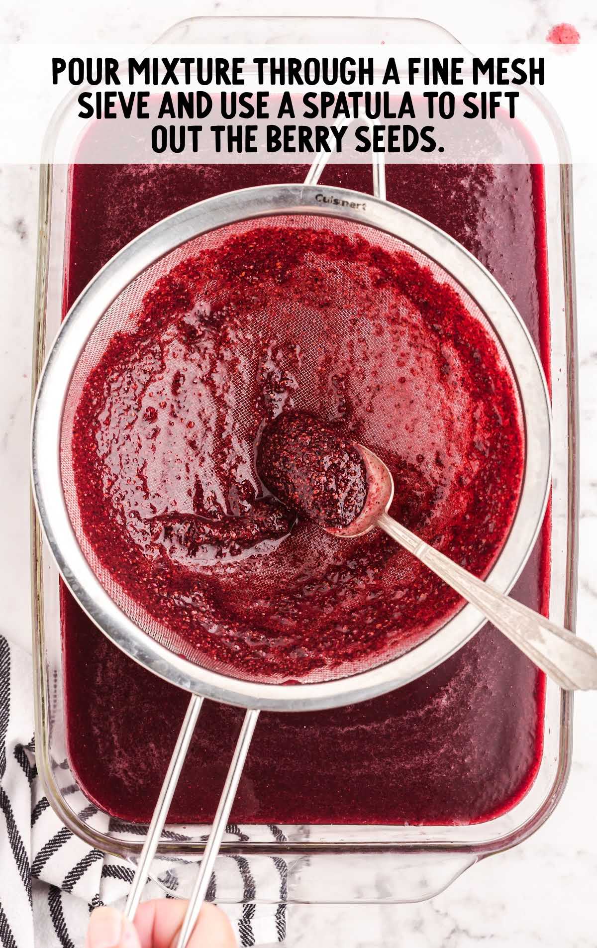 red wine mixture poured in a mesh sieve into a baking dish